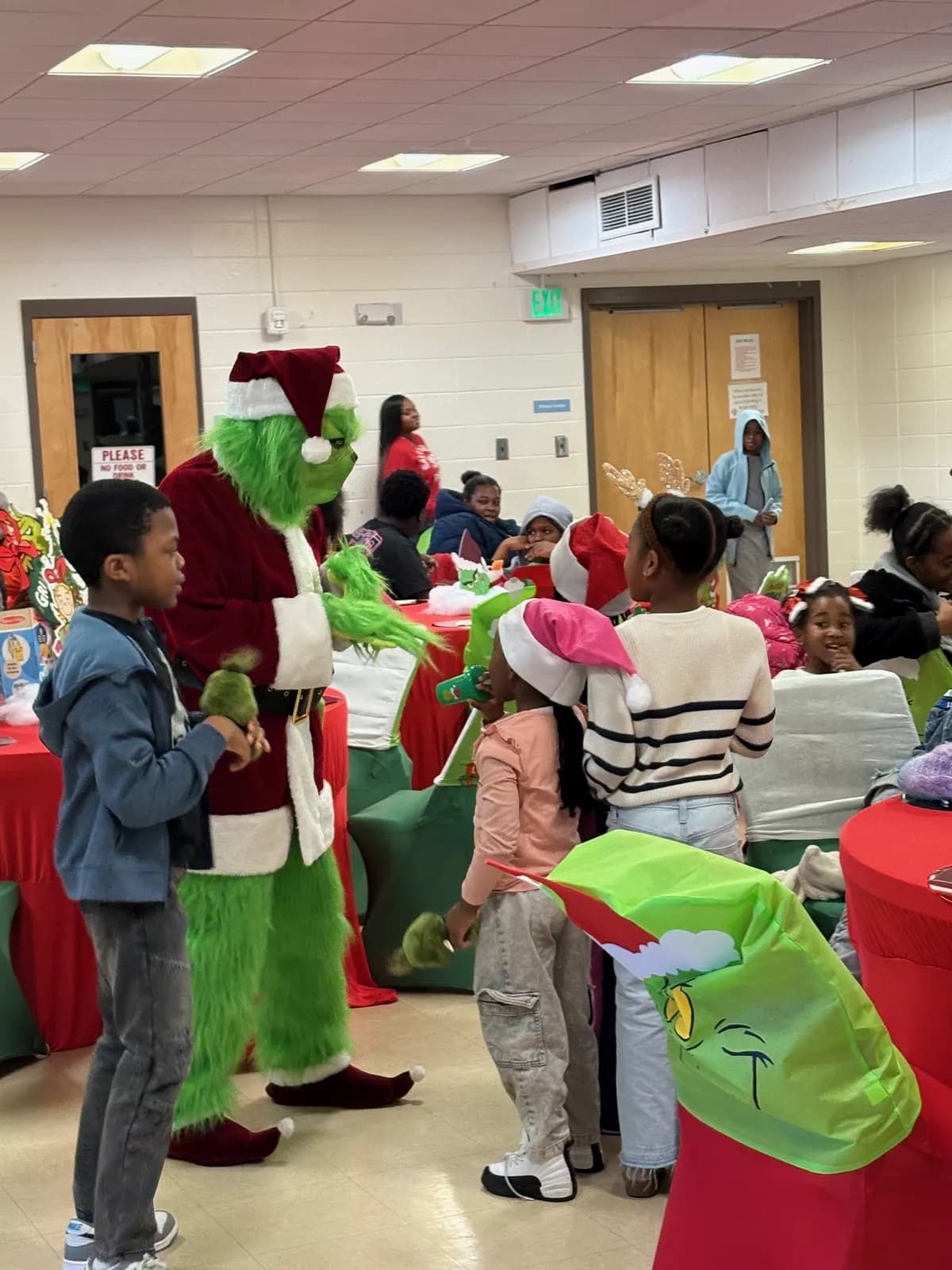 The Grinch handing out gifts to children