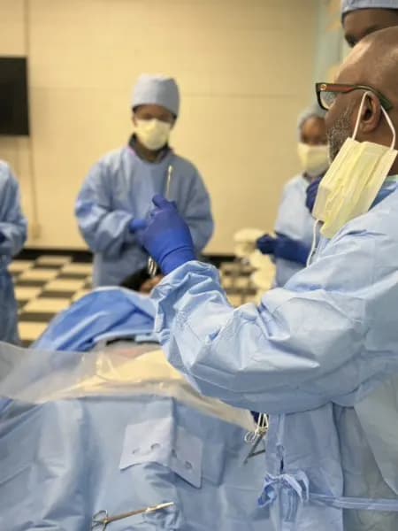 Gowned students around an operating table